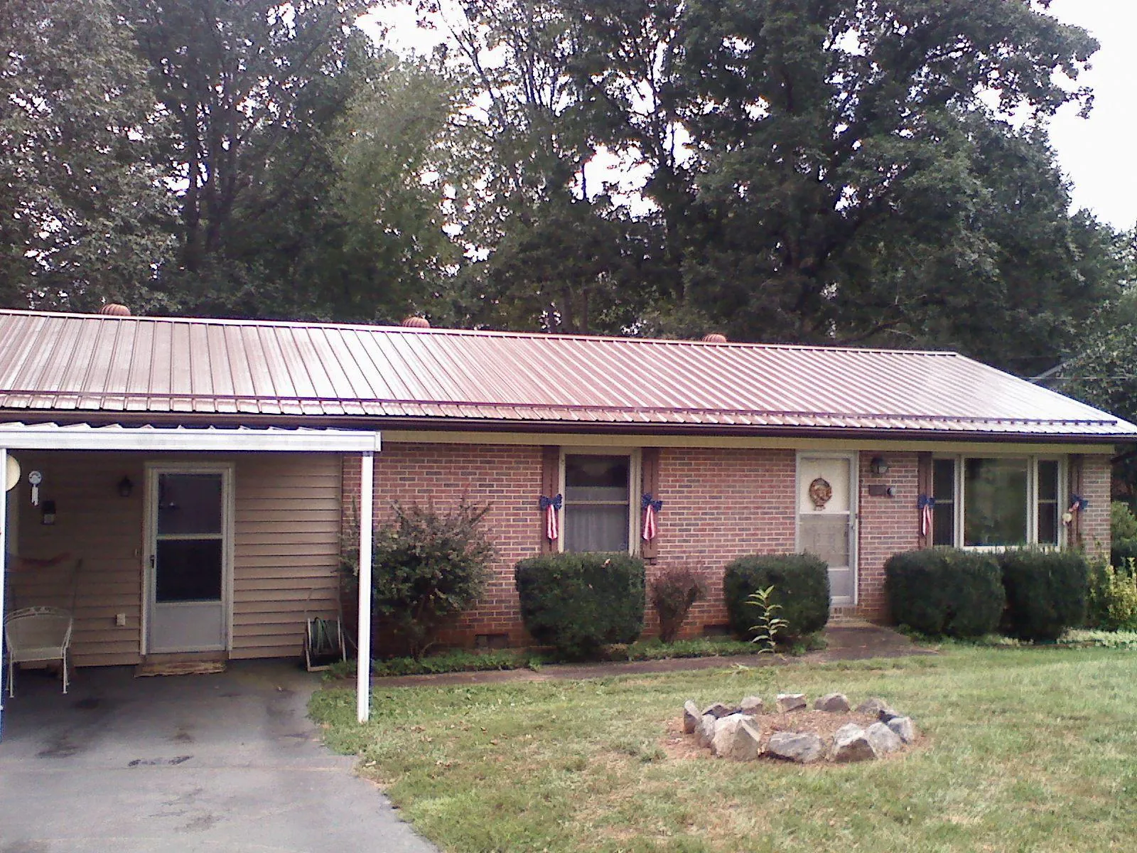 Bronze metal roof and carport on a brick ranch home — Roof Repair work by our crew in Knoxville